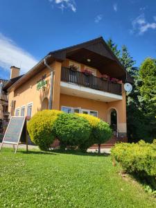 a building with a large bush in front of it at Penzion Richnava in Štiavnické Bane