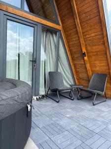 two chairs sitting on a patio with a tent at Theforestheaven in Brđani