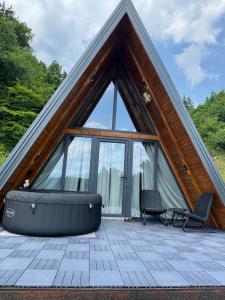 a frame house with a large window and a bath tub at Theforestheaven in Brđani