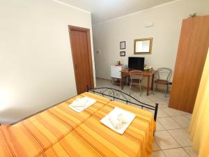 a bedroom with a bed with two towels on it at B&B Profumo di Zagara in Taormina