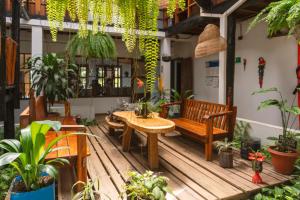 a porch with a wooden bench and potted plants at Waira Selva Hotel in Puerto Nariño