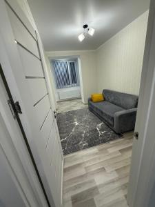 a living room with a couch and a window at Квартира в центре города in Komrat
