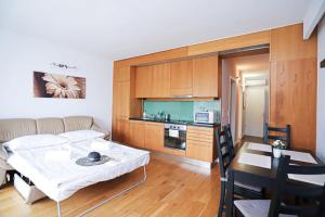 a kitchen and a living room with a table and a couch at Balino C1 in Balatonlelle