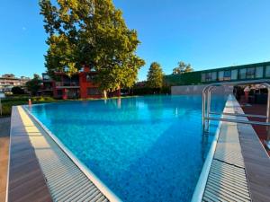 a large swimming pool with blue water in a city at Balino C1 in Balatonlelle