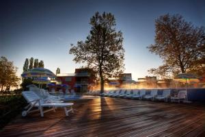 a group of chairs and umbrellas on a wooden deck at Balino C1 in Balatonlelle