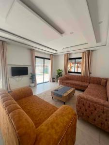 a living room with two couches and a tv at Dar sirine in Arkou