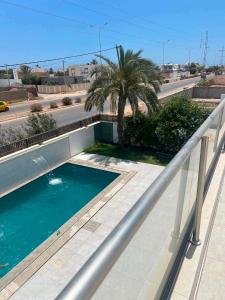 a swimming pool on a balcony with a palm tree at Dar sirine in Arkou