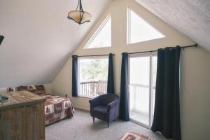 a attic bedroom with a large window and a chair at Alpine Lodge Resort in Branson +52 photos