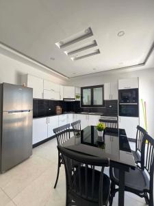 a kitchen with a table and chairs and a refrigerator at Dar sirine in Arkou