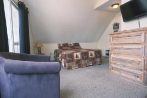 a bedroom with a bed and a couch and a tv at Alpine Lodge Resort in Branson