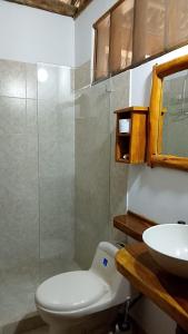 a bathroom with a toilet and a sink at Karpatty Mar Cabañas in San Bernardo del Viento