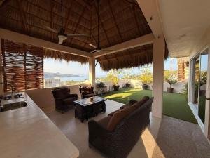 a living room with a couch and chairs and a table at Casa Maracuyá Chacala in Chacala