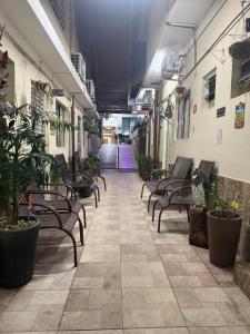 an empty hallway with chairs and plants in a building at Pousada Castro in Aparecida