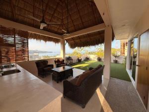 a living room with a couch and chairs and a table at Casa Maracuyá Chacala in Chacala