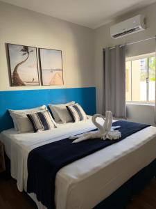 a large bed with a white flower on top of it at Barra Comfort Pousada in Salvador +88 photos
