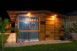 a wooden shed with a large window at night at Mar de Jade in Colán