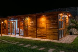 a house with wooden walls and windows at night at Mar de Jade in Colán