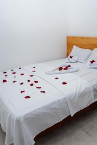 a white bed with red roses on it at Mar de Jade in Colán