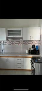 a kitchen with white cabinets and a stove at Belle villa in Toubab Dialaw
