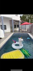 a swimming pool with a pool noodle in the water at Belle villa in Toubab Dialaw