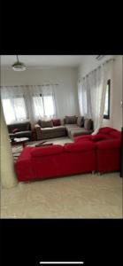 a living room with a red couch in a room at Belle villa in Toubab Dialaw