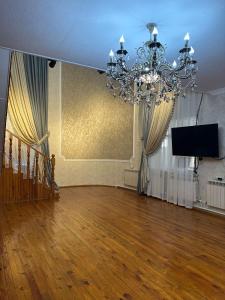 a large room with a chandelier and wooden floors at Aigul Hostel in Shymkent