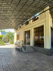 a building with a bench in front of it at Aigul Hostel in Shymkent