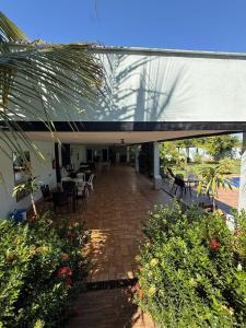 a patio with tables and chairs in a building at Refúgio Garden Eventos in Senador Canedo