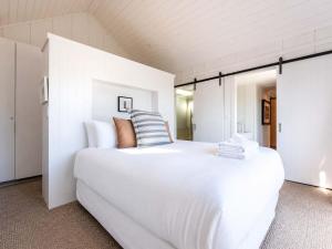 a white bedroom with a large white bed at Blackpool Boathouse - Stay Waiheke in Oneroa +36 photos