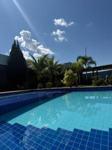 a large swimming pool with blue tiles on it at Refúgio Garden Eventos in Senador Canedo