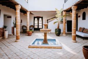 a courtyard with a fountain in the middle of a building at Riad Eucalyptus, hôtel de charme Essaouira in Essaouira