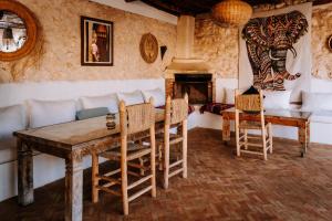 a living room with a table and chairs and a fireplace at Riad Eucalyptus, hôtel de charme Essaouira in Essaouira