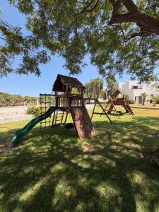 a park with two swings and a tree at Boustan homes in Cabo Negro