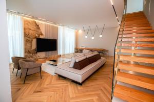 a living room with a couch and a staircase at Hilltop Villa Tirana in Mjull-Bethore