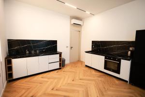 a kitchen with black and white counters and a wooden floor at Hilltop Villa Tirana in Mjull-Bethore