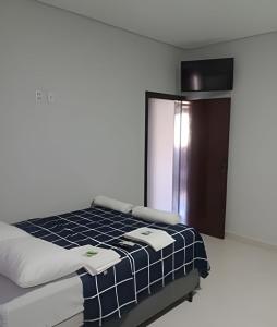 a bedroom with a bed with a blue and white blanket at Loft 2 com Ar e Garagem até 6 Pessoas Rede Urbana in Indaiatuba