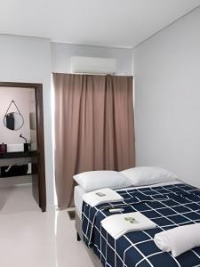 a bedroom with a bed with a blue and white at Loft 2 com Ar e Garagem até 6 Pessoas Rede Urbana in Indaiatuba
