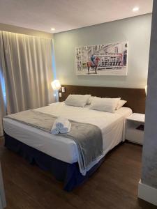 a bedroom with a large bed with white sheets at Flat Fabuloso Hotel Berrini in São Paulo +41 photos