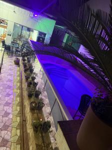 a swimming pool in a building with purple lighting at Pousada Castro in Aparecida