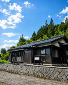 a black and white building with a stone wall at Yanagiya Iri in Nakatsugawa