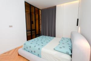 a bedroom with a white bed with blue sheets at Hilltop Villa Tirana in Mjull-Bethore +18 photos