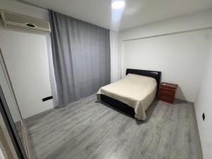 a small bedroom with a bed and a window at Joy Residence- 3 bedroom apartment with balcony in Nicosia