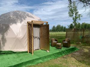 a tent with a door on a green blanket at Couple Luxury Villa in Apšuciems