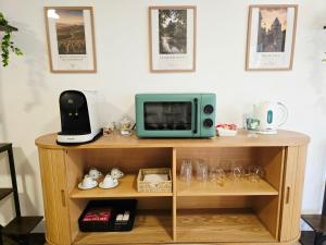 a microwave sitting on top of a wooden shelf at La Parenthèse du Buisson Bailly - Jacuzzi, Détente et Bien être près de Provins in Choisy-en-Brie