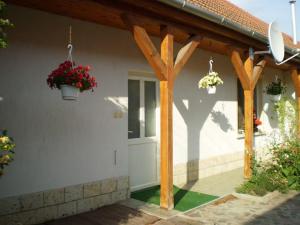 a wooden pergola with two potted plants on a house at Dóri Szálláshely in Sárospatak +11 photos