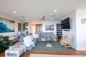 a living room with a couch and a table at Lazy Days Penthouse - Opposite Shaws Bay - 180 Waterfront Views in East Ballina