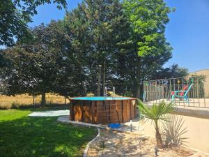a small pool in a yard with a playground at La Parenthèse du Buisson Bailly - Jacuzzi, Détente et Bien être près de Provins in Choisy-en-Brie