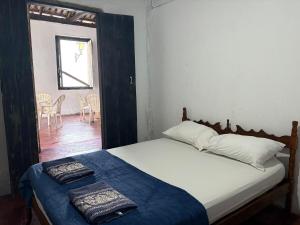 a bedroom with a bed with two towels on it at Casa Beco do Sertão - Praça do Coreto in Goiás