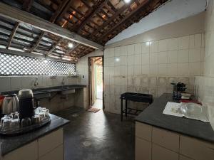 a large kitchen with a counter in a room at Casa Beco do Sertão - Praça do Coreto in Goiás