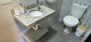 a bathroom with a white toilet and a sink at Loft 3 com ar-condicionado da Rede Urbana in Indaiatuba +29 photos